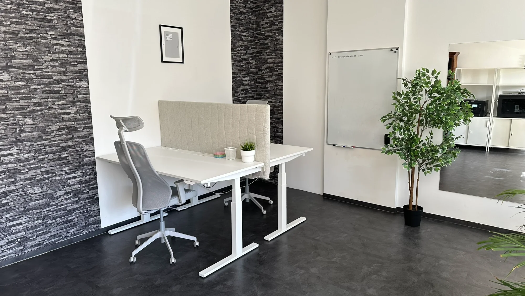 Polohovací pracovní stoly s ergonomickými židlemi a bílou tabulí